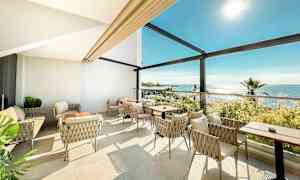 Lys sittegruppe med utsikt over havet. (AI-generert tekst)