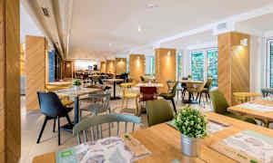 Bilde av en restaurant med bord, stoler og dekorasjoner. (AI-generert tekst)