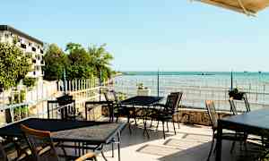 Utendørs servering med utsikt over havet og kystlandskapet. (AI-generert tekst)