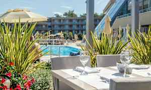 Et bord med servering, med utsikt over et basseng og en bygning i bakgrunnen. (AI-generert tekst)