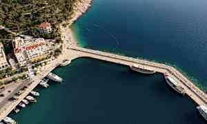 Luftfoto av en havn med båter og tilhørende bygninger. (AI-generert tekst)