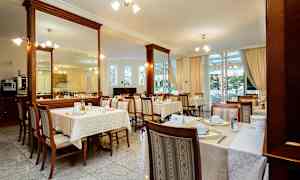 Restaurant med oppdekkede bord og stoler innendørs. (AI-generert tekst)