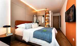 Moderne hotellrom med dobbeltseng, dekorative puter og belysning. (AI-generert tekst)