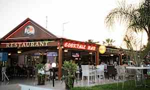 En restaurant og cocktailbar med uteservering beliggende i en hage. (AI-generert tekst)