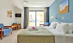 Et hotellrom med en seng, sittegruppe og en balkong. (AI-generert tekst)