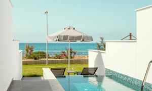 Privat basseng med utsikt over havet og grønne områder. (AI-generert tekst)