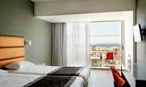 Hotellrom med to enkeltsenger og balkong med havutsikt. (AI-generert tekst)