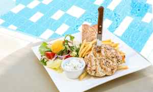 En tallerken med kylling, pommes frites, pitabrød og salat ved siden av et basseng. (AI-generert tekst)