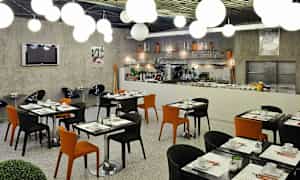 Moderne restaurantmøbler med sorte og oransje stoler samt dekte bord. (AI-generert tekst)