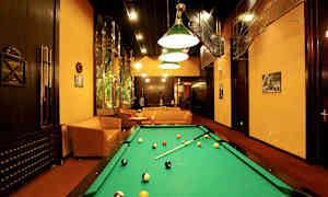 Spillerom med biljardbord, sofaer og kunstnerisk interiør. (AI-generert tekst)