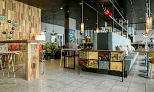 En moderne kafé eller restaurant med designinteriør, treverk og stilfull belysning. (AI-generert tekst)