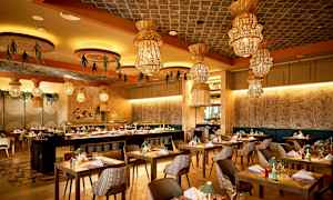 En restaurant med moderne møbler og dekorative lamper i taket. (AI-generert tekst)