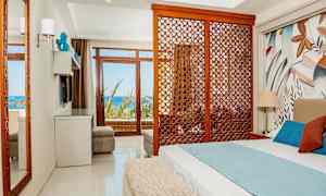 Hotellrom med seng, dekorativ trepanel og utsikt mot havet. (AI-generert tekst)