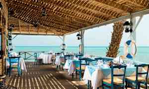 En restaurant med blå og hvite farger ved havet. (AI-generert tekst)