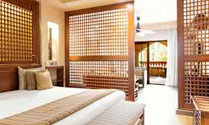 Velmøblert soverom med dekorative trepaneler som skiller av til en stue. (AI-generert tekst)