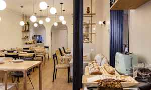 En spisesal med bord, stoler og en buffet med brød og tilbehør. (AI-generert tekst)