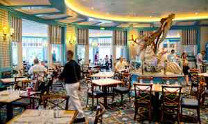 En restaurant med sitteplasser og en dekorasjon i form av en havfigur i midten. (AI-generert tekst)