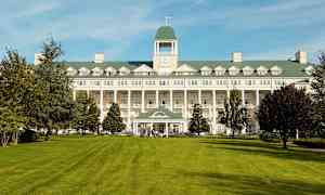 Bilde av en stor bygning med en plen i forgrunnen. (AI-generert tekst)