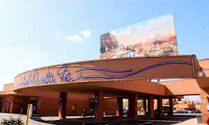 Inngangen til Hotel Santa Fe med skilt og bakgrunn med tegnet bilscene. (AI-generert tekst)