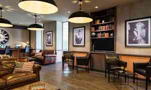 En stilfull lounge med lærmøbler og kunst på veggene. (AI-generert tekst)