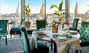 Restaurant med elegant borddekning og utsikt over byen. (AI-generert tekst)