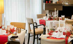 Restaurantbord med juledekorasjoner, dekket med servietter og glass. (AI-generert tekst)