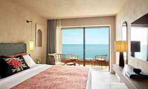 Hotellrom med havutsikt fra balkong. (AI-generert tekst)