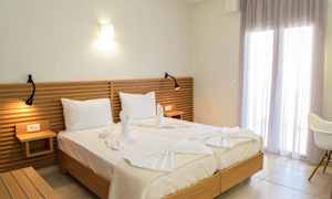 To senger med hvitt sengetøy, en tre-hodegjerde og dekorative håndklær formet som svaner. (AI-generert tekst)