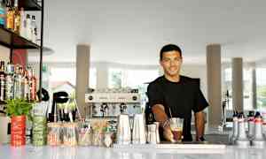 En bardisk med forskjellige flasker, redskaper og serveringstilbehør. (AI-generert tekst)