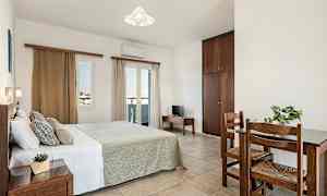 Et soverom med en dobbeltseng, et lite bord med to stoler og et skap. (AI-generert tekst)