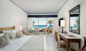 Hotellrom med havutsikt fra en terrasse. (AI-generert tekst)