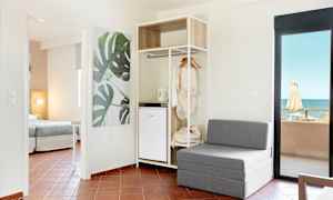 Moderne hotellrom med sittemøbler, åpen garderobe og havutsikt. (AI-generert tekst)