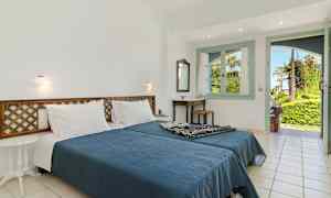 Et soverom med en dobbeltseng, et bord og en åpning mot en frodig hage. (AI-generert tekst)