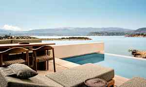 Terrasse med basseng og utsikt over hav og fjell. (AI-generert tekst)