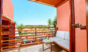 Uteområde med sitteplass og bord mot solfylt utsikt. (AI-generert tekst)