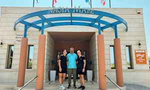 Inngangen til bygningen med skilt og flagg ovenfor. (AI-generert tekst)