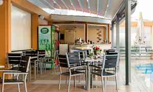 En utendørs servering med bord og stoler ved et basseng. (AI-generert tekst)