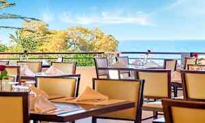 Dekorert terrasse med havutsikt. (AI-generert tekst)