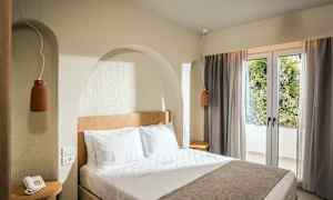 Et hotellrom med en dobbeltseng, nattbord og vindu med gardiner. (AI-generert tekst)