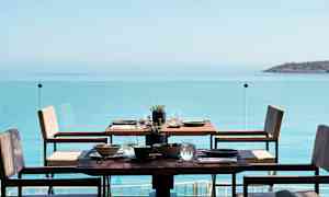 Et dekket bord på en terrasse med utsikt over havet. (AI-generert tekst)