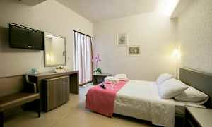 Hotellrom med dobbeltseng, nattbord og skrivebord. (AI-generert tekst)