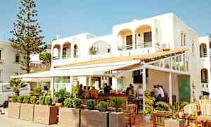 Hvit bygning med utendørs bar og sittemøbler. (AI-generert tekst)