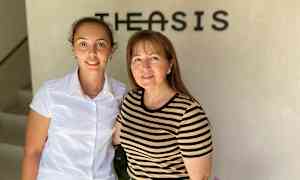 To personer står foran en vegg med en logo. (AI-generert tekst)