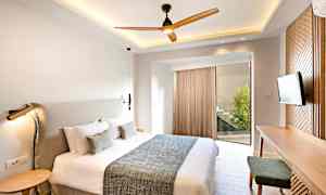 Et moderne soverom med en stor seng, et skrivebord og en TV. (AI-generert tekst)