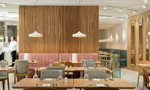 Restaurant med bord og stoler samt dekorative lamper. (AI-generert tekst)