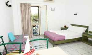 Et hotellrom med en dobbeltseng, en sofa, et bord med stoler og en balkong med utsikt. (AI-generert tekst)