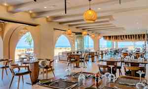 Restaurant med dekkede bord og havutsikt. (AI-generert tekst)