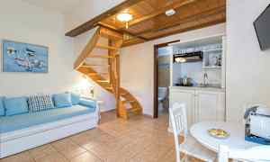 Et rom med tremøbler, en spiraltrapp, en sofa og et bord. (AI-generert tekst)