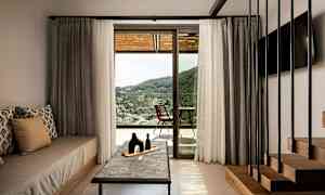 Rom med interiør og utsikt over landskapet gjennom en glassdør. (AI-generert tekst)