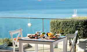 Et dekket bord med ulike retter og utsikt over havet. (AI-generert tekst)